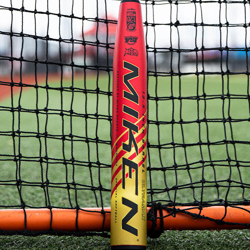 A Miken Freak Gold USSSA bat in front of a protective screen